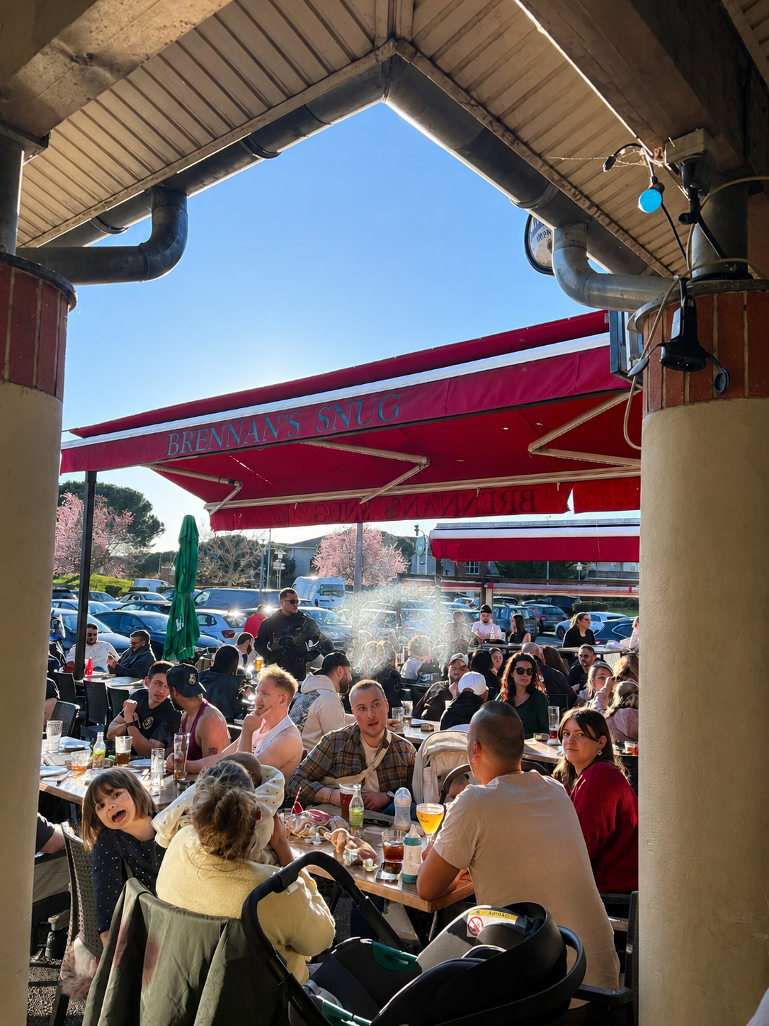 Terrasse animée du Brennan's Snug sous les stores rouges