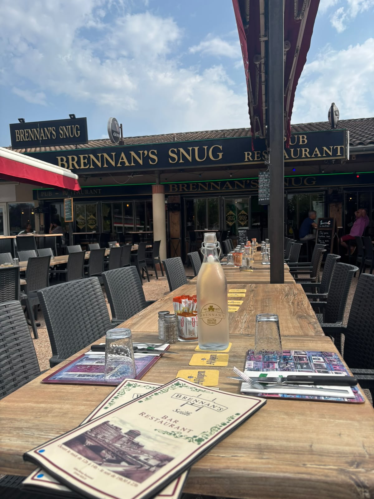 Terrasse réelle du Brennan's Snug avec ses tables et son enseigne