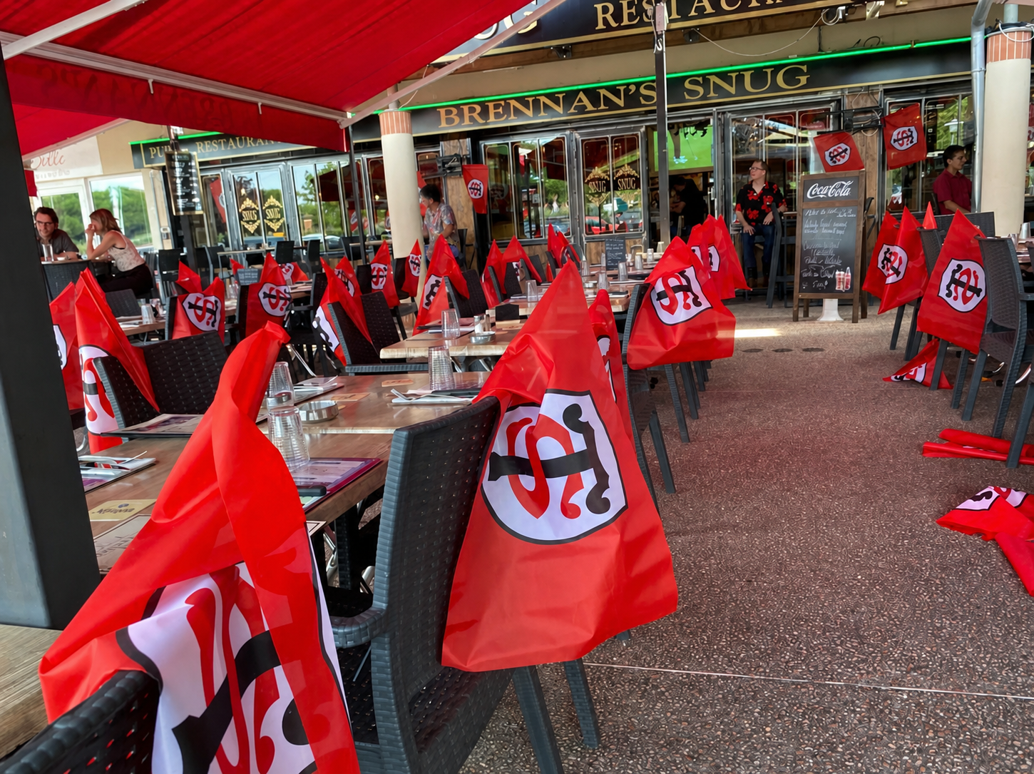 Terrasse du Brennan's Snug décorée de drapeaux rouges pour une journée de rugby